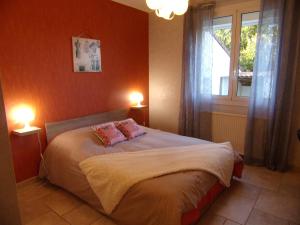 um quarto com uma cama com 2 candeeiros e uma janela em Gîte du Gecko em Saint-Christol-lès-Alès