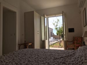 a bedroom with a bed and a sliding glass door at Casale Vignazze in Punta Secca