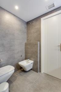 La salle de bains est pourvue de toilettes blanches et d'un lavabo. dans l'établissement by RIVA - Designer 1 Bedroom Apartment in the Centre of Marbella, à Marbella