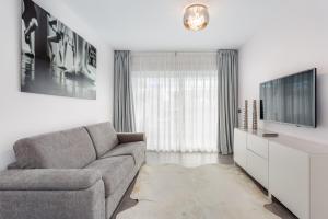 - un salon avec un canapé et une télévision dans l'établissement by RIVA - Designer 1 Bedroom Apartment in the Centre of Marbella, à Marbella