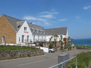 a white building with a car parked in front of it at The Prince Of Wales Hotel in St Ouen's