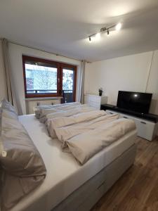a room with four beds and a flat screen tv at Appartment Fuzzy in Sölden