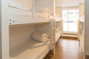 a room with two bunk beds and a window at Pars Teatro Hostel in Barcelona +50 photos