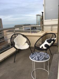 two chairs and a table on a balcony at Appartement Fr Gilkens Ostende in Ostend