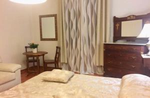 アルゲーロにあるAppartamento in Villa con Posto Autoのベッドルーム1室(ベッド1台、ドレッサー、テーブル付)