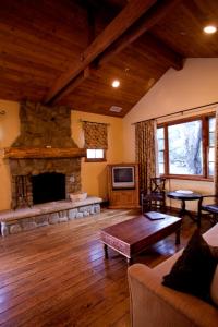 sala de estar con chimenea de piedra y sofá en Circle Bar B Guest Ranch, en Santa Bárbara