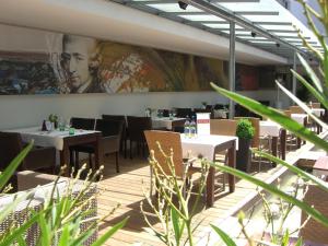 a restaurant with tables and chairs and a large painting on the wall at Gasthof OHR in Eisenstadt