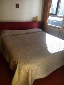 ein großes Bett in einem Schlafzimmer mit Fenster in der Unterkunft Villa Borca di Cadore in Borca di Cadore