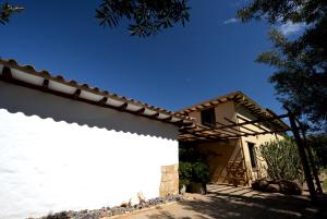 ein Haus mit einer weißen Wand davor in der Unterkunft Hotel Casa Terra in Villa de Leyva