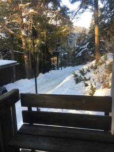 a wooden bench sitting in the snow with a view at Villa Borca di Cadore in Borca di Cadore