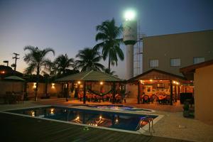 a swimming pool in front of a building at night at Taj Hotel in Três Lagoas