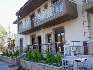 a house with a balcony with a table on it at MUSSES in Stratoni