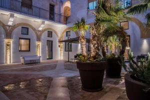 een binnenplaats van een gebouw met palmbomen bij Chiostro di S. Antonio in Marsala