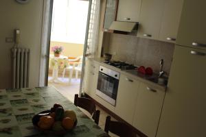 a kitchen with a table with a bowl of fruit on it at Gallipoli Casa Anna 7 posti letto 200 mt dalla spiaggia in Gallipoli