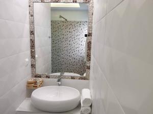 een badkamer met een witte wastafel en een spiegel bij Sea Breeze Villa in Charaki