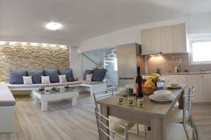 a kitchen and living room with a table and a couch at Sea Breeze Villa in Haraki
