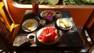 a table with plates of food and fruit on it at Embassy House in Puerto Jiménez