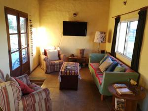 a living room with couches and a flat screen tv at Hostel de campo La Providencia in Lobos