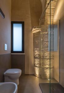 een badkamer met toilet en glazen douche bij Chiostro di S. Antonio in Marsala