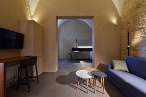 a living room with a blue couch and a piano at Chiostro di S. Antonio in Marsala
