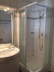 y baño con ducha y lavamanos. en Studio Bel-Hüs / Bel-Häx en Blatten bei Naters