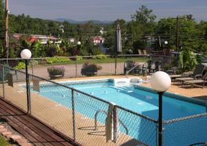 a swimming pool with a fence around it at Bay Top Motel in Weirs Beach +16 photos