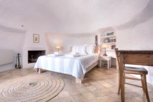 a bedroom with a large white bed and a fireplace at Can Quince de Balafia - Turismo de Interior in Sant Llorenç de Balafia