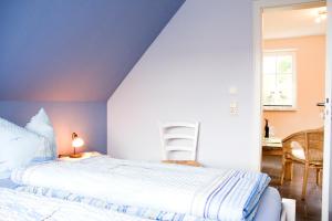 1 Schlafzimmer mit einem weißen Bett und einer blauen Decke in der Unterkunft Die Kleine Ferienwohnung in Prerow