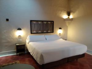 een slaapkamer met een groot wit bed en 2 verlichting bij Beach Hotel Dos Mares in Tarifa