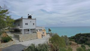 a house with a cow on top of it next to the ocean at Skouros Villa in Kastrí