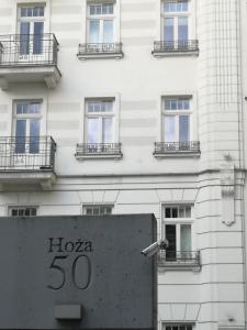 華沙的住宿－Apartment Hoża 50 with a balcony in close Center，前面有标志的建筑