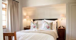 博福特西的住宿－Beaufort Manor Country Lodge，卧室配有一张带白色床单和枕头的大床。