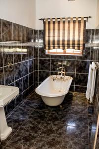 a bathroom with a tub and a sink at Beaufort Manor Country Lodge in Beaufort West