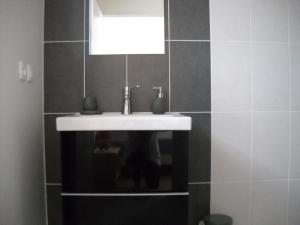 a bathroom with a white sink and a mirror at LES HAUTS DE JALLIA in Sainte-Jalle