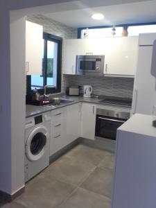a kitchen with a sink and a washing machine at CASA SERAFIN primera linea 40B in Costa Teguise