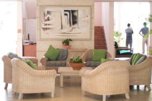 a living room with chairs and a table with green pillows at Hotel PomMarine in Bridgetown