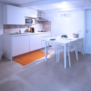a white kitchen with a white table and chairs at SpAsimoH-2 in Palermo