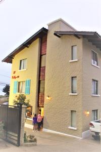 a group of people standing outside of a building at Hostal El Gallego in El Quisco