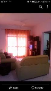 a living room with a couch and a window at Apto em Lindóia in Lindóia