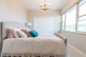 a bedroom with a white bed with a chandelier at Shabby Chic Abode - Minutes to Manhattan in Weehawken