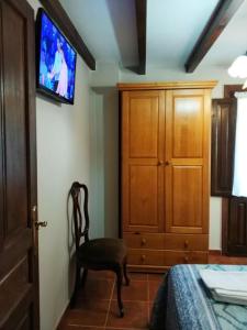 um quarto com uma cadeira e uma televisão na parede em El Cantón em Cangas de Onís
