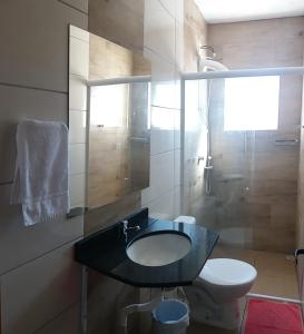 a bathroom with a sink and a toilet and a shower at Hotel Majestic in Pelotas