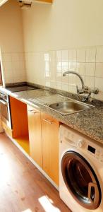 a kitchen with a sink and a washing machine at City Heart Rooms in Porto