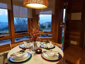 uma mesa de jantar com uma toalha de mesa branca e um lustre em Landecoira em Sequeiro