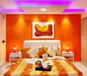 Villa Araçà - Boutique Hotel في لورو دي فريتاس: غرفة نوم بسرير كبير بجدران برتقالية