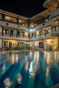 une piscine vide dans un bâtiment la nuit dans l'établissement El Virrey Hotel Boutique, à Honda