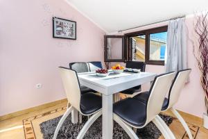 a dining room with a white table and chairs at Apartment Sea View in Kotor +26 photos