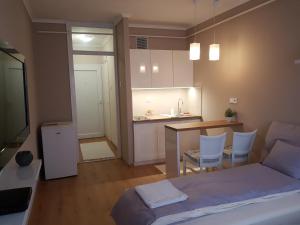 sypialnia z łóżkiem oraz kuchnia ze stołem w obiekcie Lia Apartman w Nyíregyházie