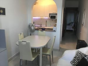 a kitchen and dining room with a table and chairs at Beachfront Deluxe Apartment in Marsalforn