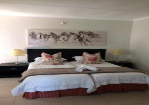 a bedroom with a large bed with two pillows at Wagon Wheel Country Lodge in Beaufort West
